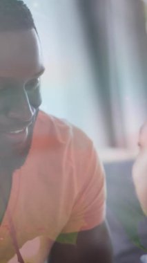 Mutlu Afrika kökenli Amerikalı baba ve oğulun kanepede kucaklaşması üzerine yaprakların animasyonu. aile, birliktelik, kaliteli zaman konsepti dijital olarak oluşturulmuş video.