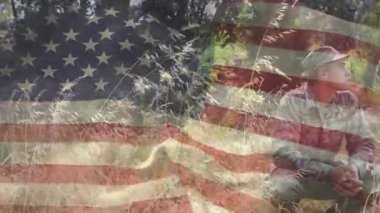 Doğal ortamında Amerikan bayrağı animasyonu olan bir adam sahada oturuyor. Vatanseverlik, açık hava, doğa, özgürlük, kırsal, sükunet