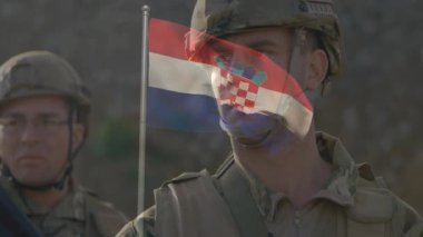 Hırvat bayrak animasyonuyla, üniformalı askerler bir arada duruyorlar. Ordu, vatanseverlik, birlik, disiplin, savunma