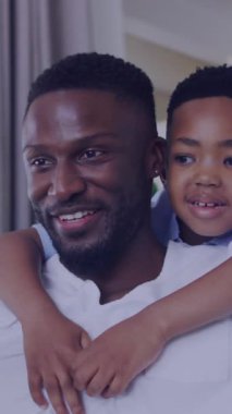 Mutlu Afro-Amerikan baba ve oğlunun selfie çekmesi üzerine ışık animasyonu. aile, birliktelik, teknoloji konseptiyle dijital olarak oluşturulmuş video ile zaman geçirme.