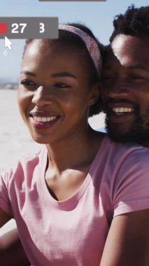 Akıllı telefonlu Afro-Amerikan çiftin medya simgelerinin canlandırılması. Sosyal medya ve iletişim arayüzü kavramı dijital olarak oluşturulmuş video.