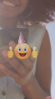 Açık havada akıllı telefon kullanan melez bir kadının orta bölümündeki duygu simgelerinin canlandırması. küresel bağlantılar, sosyal medya, teknoloji ve dijital arayüz konsepti dijital olarak oluşturulmuş video.