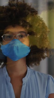 Yüzü maskeli Afro-Amerikan bir kadın üzerinde ışık lekeleri. Dijital olarak oluşturulan covid 19 pandemik konsept sırasında sosyal medya ve iletişim arayüzü.