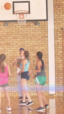 Beden eğitiminde basketbol oynayan çeşitli okul çocuklarının üzerinde ışık lekeleri. Ulusal Okul Spor Haftası ve dijital olarak oluşturulan kutlama konsepti.