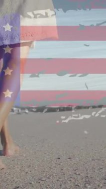 Sahilde yürüyen Afro-Amerikan kadın üzerine Amerikan bayrağı animasyonu. Vatanseverlik ve kutlama konsepti dijital olarak oluşturulmuş video.