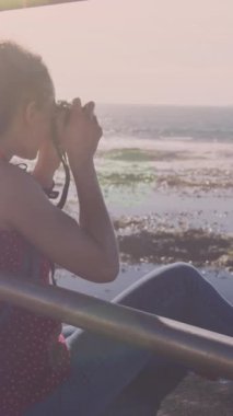 Gezinti güvertesinde kamerayla fotoğraf çeken melez bir kadının üzerindeki ışık lekelerinin canlandırması. sağlık ve zindelik kavramı dijital olarak oluşturulmuş video.