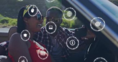 Üstü açık arabalarda, animasyon teknolojisi temalı dijital simgelerle çevrili çift. yenilik, iletişim, fütüristik, bağlantı, etkileşim