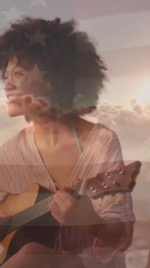 Sahilde gitar çalan mutlu melez kadın yerine Amerika Birleşik Devletleri bayrağının animasyonu. Amerikan vatanseverliği ve bağımsızlık kavramı dijital olarak oluşturulmuş video.