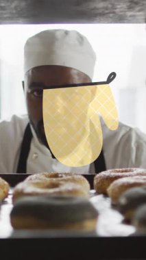 Afro-Amerikan erkek fırıncının çörek hazırlayan fırın eldiveni ikonlarının animasyonu. Ulusal pasta günü ve dijital olarak üretilen video konsepti.