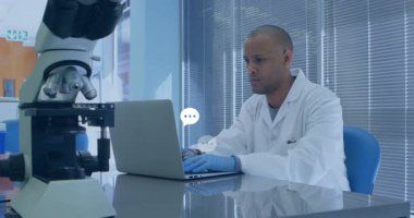 Laboratuvar önlüklü bilim adamı sohbet baloncuğu animasyonuyla dizüstü bilgisayarda çalışıyor. Laboratuvar, araştırma, analiz, yenilik, dijital iletişim, teknoloji