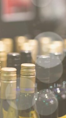 Animation of bokeh over wine bottles at shop. wine business, tasting and celebration concept digitally generated video.
