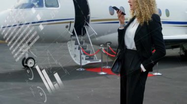 Telefonda konuşan, özel jetin yanında animasyon veri grafikleri olan bir iş kadını. İş seyahati, havacılık, yürütme, teknoloji, iletişim, analitik