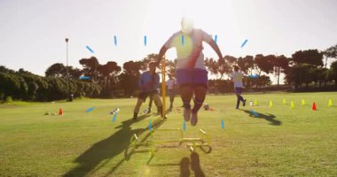 Çimenli alanda antrenman, futbol oyuncuları çeviklik ekipmanları ve koniler kullanıyor. egzersiz, fitness, spor, takım çalışması, rekabet, koordinasyon