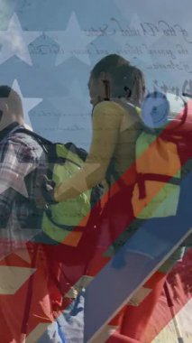 Dağlarda yürüyüş yapan gülümseyen çift üzerine Amerikan bayrağı animasyonu. Vatanseverlik ve kutlama konsepti dijital olarak oluşturulmuş video.