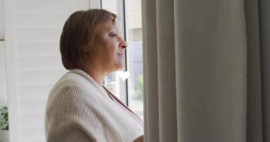 Etrafında kalp animasyonlarıyla pencereden dışarı bakan bir kadın. Rüya, romantik, yansıma, yalnızlık, tefekkür, aşk