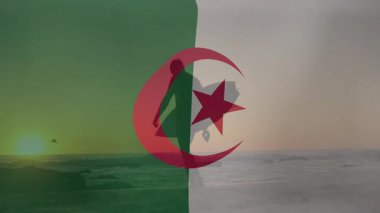 Gün batımında sahilde yürüyen köpekler, Cezayir bayrağı animasyonu ile siluet. Kıyı şeridi, hayvanlar, doğa.