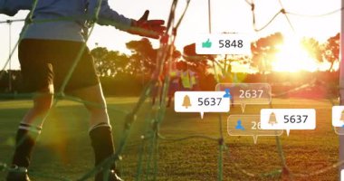 Çocuklar gün batımında sosyal medya bildirimleriyle futbol oynuyorlar. Spor, takım çalışması, gençlik, açık hava, dijital medya, arkadaşlık