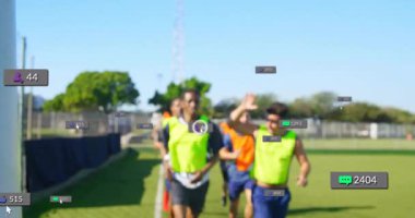 Sahada koşan sporcular, dijital veri ve istatistiklerin animasyonuyla üst üste biniyor. Spor, teknoloji, fitness, rekabet, performans