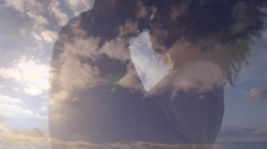 Arka planda bulutların ve gökyüzünün animasyonuyla kucaklaşan çift. Aşk, aşk, sevgi, kucak, ilişki