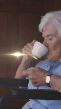 Işık animasyonu, tekerlekli sandalyede kahve içen yaşlı, beyaz bir kadının üzerinde hareket ediyor. emeklilik, ev hayatı ve umut kavramı dijital olarak oluşturulmuş animasyon.