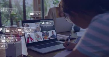 Masa başında çalışmak, video görüntülü konuşma ve simgelerle dizüstü bilgisayar kullanan biri. Uzaktan çalışma, çevrimiçi öğrenme, teknoloji, sanal buluşma, iletişim, bağlantı