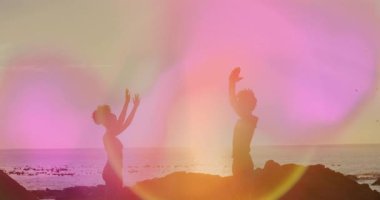Kayalık sahilde dans etmek, renkli animasyon ışığı efektleri olan insanlar. Dans, coşku, enerji, yaratıcılık, performans, festival