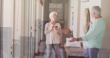 Neşeli bir şekilde dans eden yaşlı bir çift evlerinin parlak koridorunda animasyonun tadını çıkarıyorlar. Yaşlılar, mutluluk, yaşam tarzı, dans, oturma odası, hareket