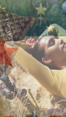 Dağlarda yatan melez bir kadının üzerine Amerikan bayrağının animasyonu. Vatanseverlik ve kutlama konsepti dijital olarak oluşturulmuş video.