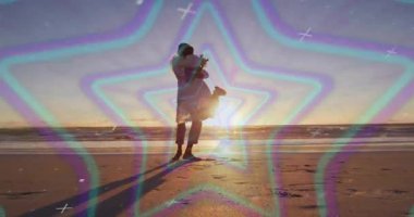 Sahilde, renkli yıldız animasyonlarıyla sarılan siluetli bir çift. Romantik, deniz kenarı, aşk, gün batımı, birliktelik, soyut