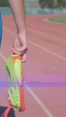 Koşu pistinde yürüyen koşu ayakkabısı tutan kadının orta kısmında hareket eden ışık animasyonu. spor, sağlıklı, aktif yaşam tarzı ve pozitiflik konsepti dijital olarak oluşturulmuş animasyon.