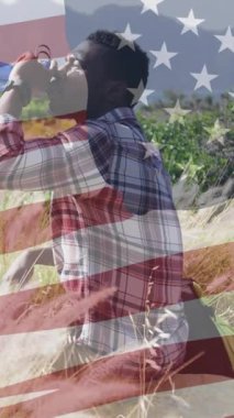 Amerikan bayrağının dağlarda su içen Afro-Amerikan bir adam üzerinde canlandırılması. Vatanseverlik ve kutlama konsepti dijital olarak oluşturulmuş video.