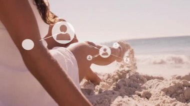 Kumsalda dinlenen, kafasının üstünde canlı bağlantıları olan biri. Bağlantı, dijital, rahatlama, teknoloji, iletişim, tatil