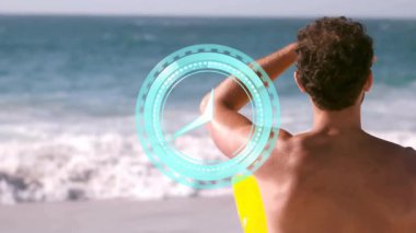 Sahilde, üzerinde dijital saat animasyonu olan sörf tahtası tutan bir adam. Sörf, tropikal, yaşam tarzı, yaz, okyanus