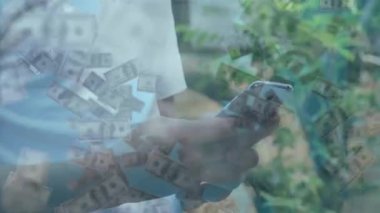 Suyun üstünde yüzen dolarlarla akıllı telefon, yeşil yapraklara karşı duran insan. Teknoloji, finans, zenginlik, yatırım, açık hava, mobil bankacılık