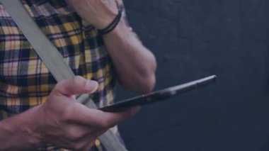 Tablet kullanarak, ekose gömlekli bir insan ekranda animasyonla dışarıda yürüyor. Teknoloji, hareketlilik, yenilik