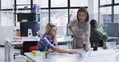 Modern ofisten iki kadın, animasyonla tasarım projesinde işbirliği yapıyor. Takım çalışması, işbirliği, yaratıcı, beyin fırtınası, profesyonel