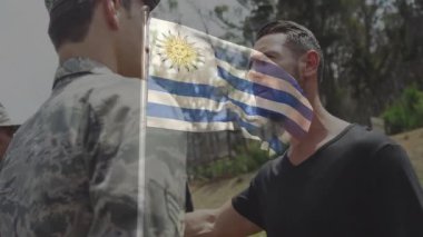 Açık havada Uruguay bayrağı animasyonu yapan ordu subayı ve sivil. Tören, vatanseverlik, üniforma, ulusal bayrak, kutlama, ulusal kimlik