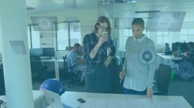 Ofiste, iki kişi dijital arayüz animasyon örtüsüyle planları tartışıyor. İşbirliği, takım çalışması, teknoloji, yenilik, beyin fırtınası, strateji