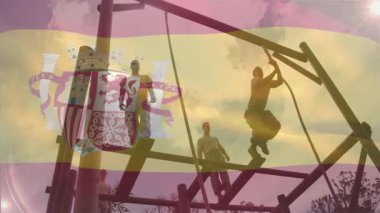 Engel parkuruna tırmanan, arka planda İspanyol bayrağı animasyonu olan insanlar. Macera, takım çalışması, meydan okuma, açık hava, rekabet, fitness