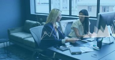 Ofis masasında veri analizi animasyonlarıyla çalışan iki kadın. İş, teknoloji, takım çalışması, işbirliği, dijital