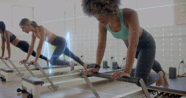 Dijital dalga animasyonu ile yenilikçi makineler üzerinde egzersiz yapan kadınlar. Pilates, fitness, egzersiz, sağlık, teknoloji
