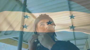 Miğfer takan, Honduras bayrağı taşıyan okul ortamında jestler yapan bir adam. milliyet, kültür, eğitim, sembol, gurur