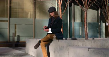Dışarıdaki telefonları kullanarak, sosyal medya ikonlarının animasyonunu yapan bir adam. Teknoloji, akıllı telefon, iletişim, bağlantı, dijital, etkileşim