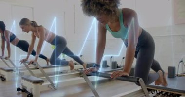 Reform makineleri üzerinde egzersiz yapan, kalp atışı animasyonu olan kadınlar spor salonunda üst üste biniyor. Fitness, pilates, egzersiz, eğitim, sağlık, kardiyo