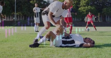 Yaralı takım arkadaşına sahada yardım etmek, veri animasyonu yapan futbolcu. Spor, takım çalışması, yardımcılar, sporcu, dijital, teknoloji