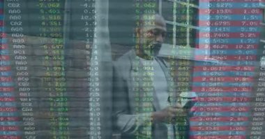 Tuğla duvara karşı duran, takım elbiseli adam ve animasyon finansal veri örtüsü. İş, finans, teknoloji, analitik, şirket, dijital