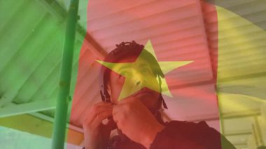 Üzerinde Kamerun bayrağı olan miğfer, animasyon temalı açık hava ortamında bir adam. Futbol, kültür, kostüm, milli gurur, kostüm, fan