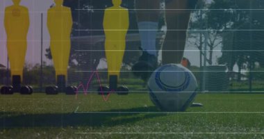 Sahada topu olan futbolcu, finansal veri animasyonu örtüşüyor. Spor, atlet, teknoloji, analiz, rekabet, finans