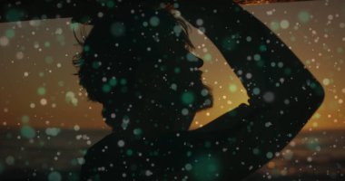 Gün batımında sahilde dijital arayüz örtüsü tasarlayan bir adamın silueti. Teknoloji, yenilik, tefekkür, fütürist, dinginlik, sükunet