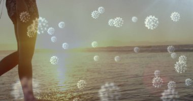 Plaj boyunca yürüyen, salgının etkilerini sembolize eden virüs çizimlerine sahip biri. Sağlık, salgın, deniz kenarı, güvenlik, farkındalık, dikkat